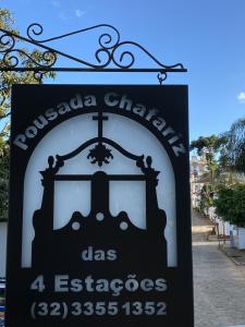 Una señal para una iglesia con una cruz. en Pousada Chafariz das 4 Estações, en Tiradentes