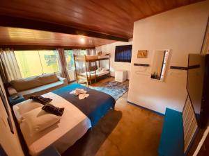 a bedroom with a bed and a living room at Vila Pequeá Ilhabela in Ilhabela