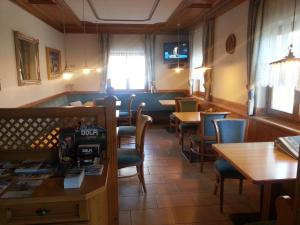 une salle à manger avec des tables et des chaises ainsi qu'un bar dans l'établissement Pension Panorama, à Monguelfo-Tesid