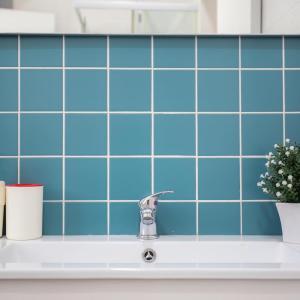 a bathroom sink with blue tiles on the wall at Apartamentos com Historia in Coimbra