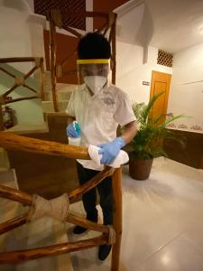 a man wearing a mask and blue rubber gloves at Hotel Real Colonial in Valladolid