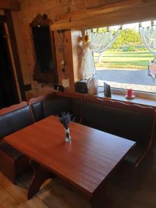 a wooden table with a vase of flowers on it at Namelis in Einoriai