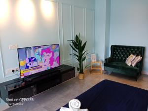 een woonkamer met een flatscreen-tv en een bank bij Imperio Residence City View in Melaka