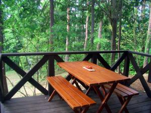 una mesa de picnic de madera y un banco en una terraza de madera en Shikitei, en Fujiyoshida