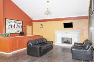 a living room with two leather chairs and a fireplace at Super 8 by Wyndham Wendover in Wendover