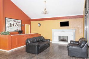 sala de estar con 2 sillas de cuero y chimenea en Super 8 by Wyndham Wendover, en Wendover