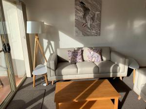 a living room with a couch and a table at BlueWater Apartments in Merimbula