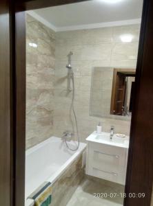 uma casa de banho com uma banheira e um lavatório em Просторные апартаменты Бариса Гмыри 14б em Kiev