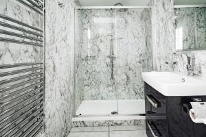 a bathroom with a tub and a sink and a shower at The Rectory Rooms, Studio 4 in Skipton