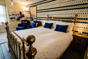 een slaapkamer met een groot bed met blauwe kussens bij The Rectory Rooms, Studio 2 in Threshfield