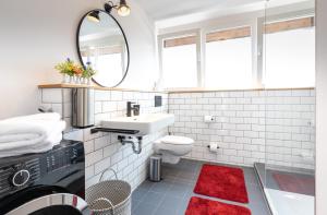 a bathroom with a sink toilet and a mirror at WÄLDER: Quartier Titisee in Titisee-Neustadt +45 photos