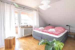 a bedroom with a bed and a large window at WÄLDER: Quartier Titisee in Titisee-Neustadt