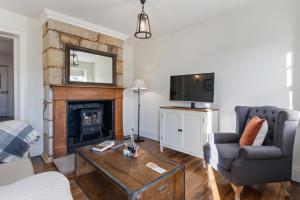 a living room with a fireplace and a tv at Lythgo's Row Colonial Cottages in Pontville