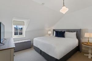 a bedroom with a large bed and a window at Lythgo's Row Colonial Cottages in Pontville