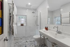 a white bathroom with a toilet and a sink at Lythgo's Row Colonial Cottages in Pontville +39 photos