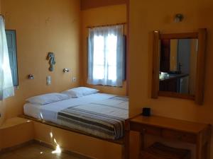 a bedroom with a bed and a mirror at Merovigla Studios in Imerovigli