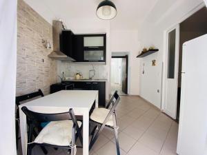 eine Küche und ein Esszimmer mit einem weißen Tisch und Stühlen in der Unterkunft Hercules House in Sarandë