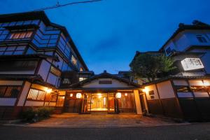 a couple of buildings at night at Seikiro Ryokan Historical Museum Hotel in Miyazu