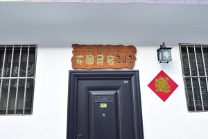 a sign above a black door in front of a building at Qufu Garden Hotel in Qufu