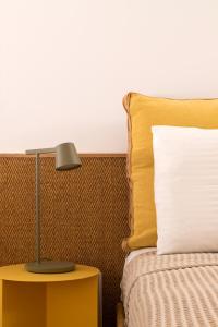 een bed met een lamp op een bijzettafel met een kussen bij Guesthouse Niriides in Spetses