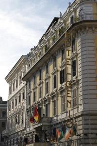 un gran edificio con banderas a un lado en Hotel Genio en Roma