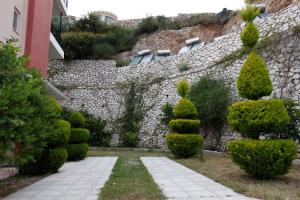 a garden with trees and a stone wall at Katerina Lefkada in Vasiliki