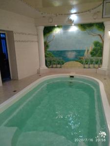 a swimming pool in a building with a painting on the wall at White House Apartments in Odesa
