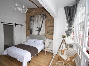 a bedroom with a bed and a brick wall at Hotel A Falúa in Puentedeume