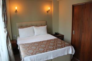 アーブシャ島にあるAlâ Avsa Hotelのベッドルーム1室(白いシーツと枕のベッド1台付)