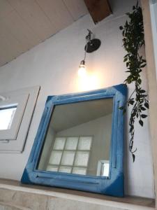 a blue mirror sitting on a shelf with a plant at la casita in Le Bourg-dʼOisans