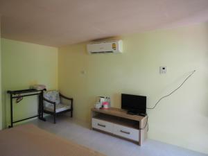 sala de estar con TV y escritorio con aire acondicionado en Pattama Resort @ KeereWong, en Kiriwong