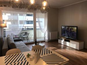 a living room with a couch and a television at Apartament Aquasfera in Reda