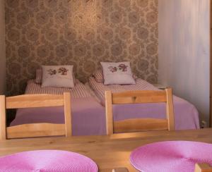 2 aparte bedden in een kleine kamer met roze kussens bij Kierinki Village Lomahuoneisto in Kierinki