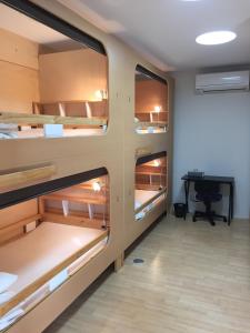 een kamer met meerdere stapelbedden en een bureau bij Guesthouse Channel-Kan in Kamojima