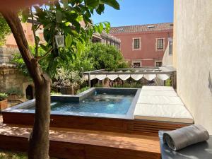 a swimming pool with a table and a tree at Relais 147 - Luxury b&b in Taormina