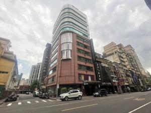 een hoog gebouw aan de kant van een stadsstraat bij Meadow Hotel Taipei in Taipei