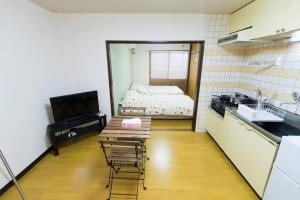 松戶的住宿－松戸Cozy1DK Nomad松戸宿049，一个带水槽的厨房和一张位于客房内的床