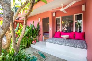 a room with pink pillows on the porch of a house at PinkPrivate Sanur - for Cool Adults Only in Sanur