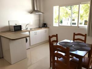 cocina con mesa, mesa pequeña y sillas en Apartamentos Carmen Teresa, en Torremolinos