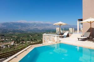a swimming pool with a view of the mountains at Villa Galanis in Kalamitsi Amygdali