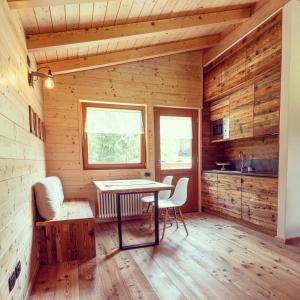 comedor con mesa y sillas en una cabaña en I Larici Camping Lodge, en Ossana