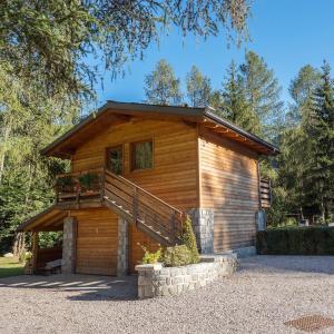 uma cabana de madeira com uma escada em frente em I Larici Camping Lodge em Ossana