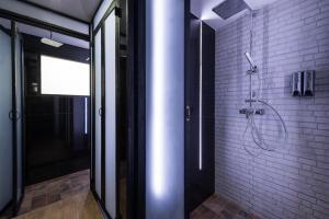 a bathroom with a shower with a white brick wall at 33 Poshtel in Chiang Mai