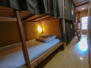- une chambre avec 2 lits superposés et une lampe dans l'établissement Gion Kyoto Miyagawacyo Guesthouse HANAKANZASHI, à Kyoto