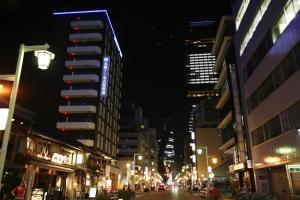 una calle de la ciudad por la noche con edificios altos en Meitetsu Inn Nagoya Sakuradori, en Nagoya