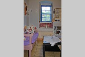 a living room with a purple couch and a table at Iliana's courtyard in Evdilos +25 photos