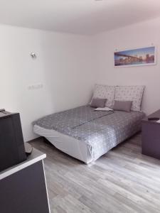 a bedroom with a bed in the corner of a room at NATA Apartman in Gyula