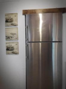 einem Kühlschrank aus Edelstahl in einer Küche mit Wandzeichnungen in der Unterkunft On the beach in Koutsounári
