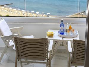 einen Tisch mit einem Teller Essen und zwei Stühlen in der Unterkunft Mackenzie Leo Seafront Suite in Larnaka