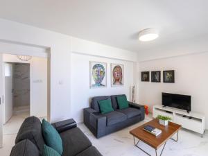 a living room with a couch and a table at Mackenzie Leo Seafront Suite in Larnaka